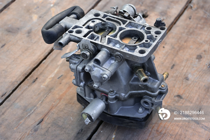 Close-up of a gasoline carburetor. Car repair in the workshop. carburetor isolated. removed from the engine. wooden background.