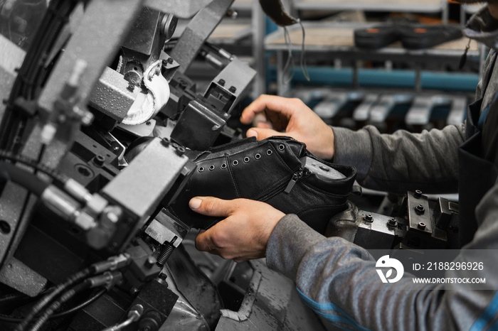 Man use special machine tool for making a shoes. The conveyor on a shoes factory with shoe and sole. Mass production of footwear.