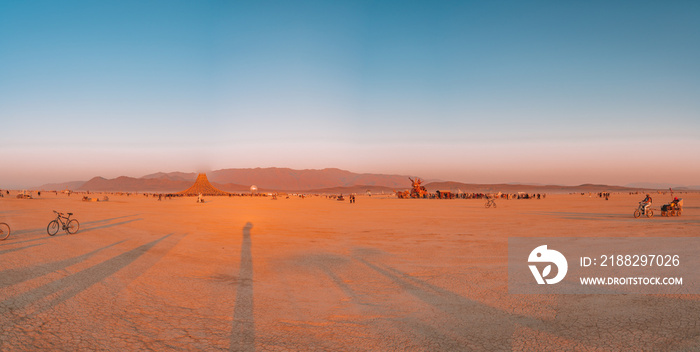Amazing sunrise view over the desert with people walking on the horizon