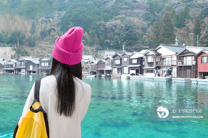 A teenage girl stands looking at a seaside village with a peaceful and relaxing atmosphere.Concept travel