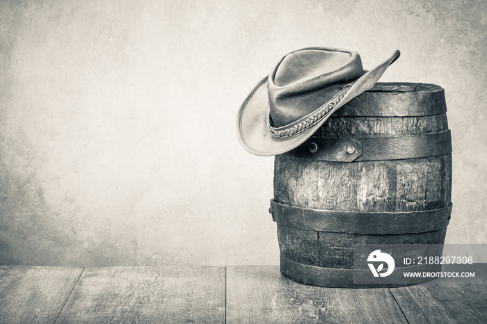 Wild West old retro hat and oak barrel. Vintage style sepia photo