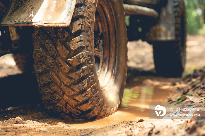 Part of an off-road vehicle on a dirt road with warm light. Adventure concept.Tire off-road on mud