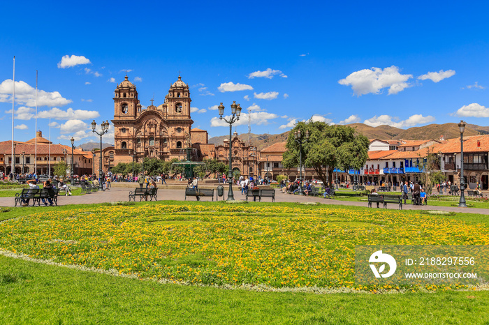 Plaza de Armas main square with cathedral and yellow flowers  in foreground, Cuzco, Peru