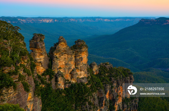 Three Sisters landmark in front of a backdrop of the Blue Mountains landscape just after sunset in NSW, Australia