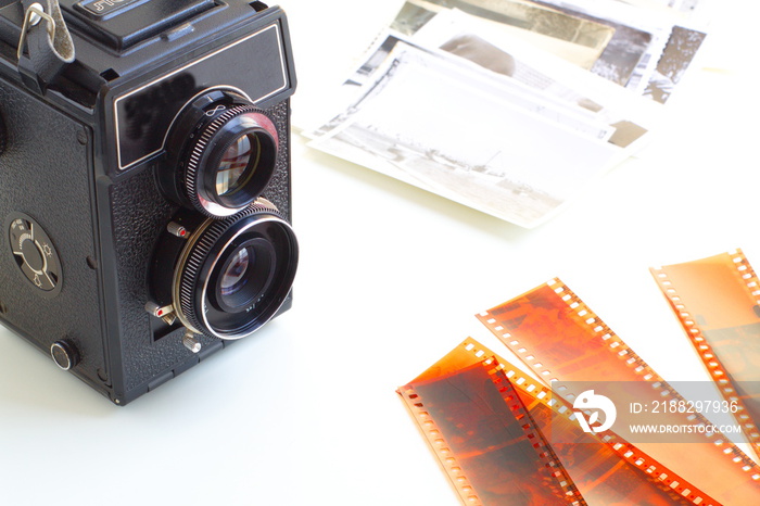 Old photo camera with negatives and photos taken