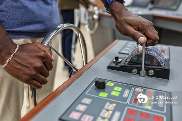 Captain’s hands at the helm of a boat.