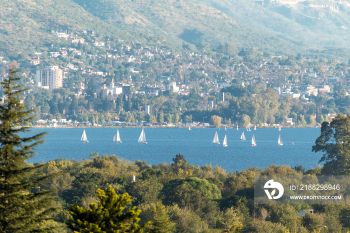 Barcos y botes en el lago San Roque, provincia de Cordoba, Argentina. Vista desde el cerro de las embarcaciones con la ciudad de Carlos Paz de fondo.