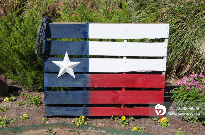 Texas state flag painted on a wood pallet with barbed wire.