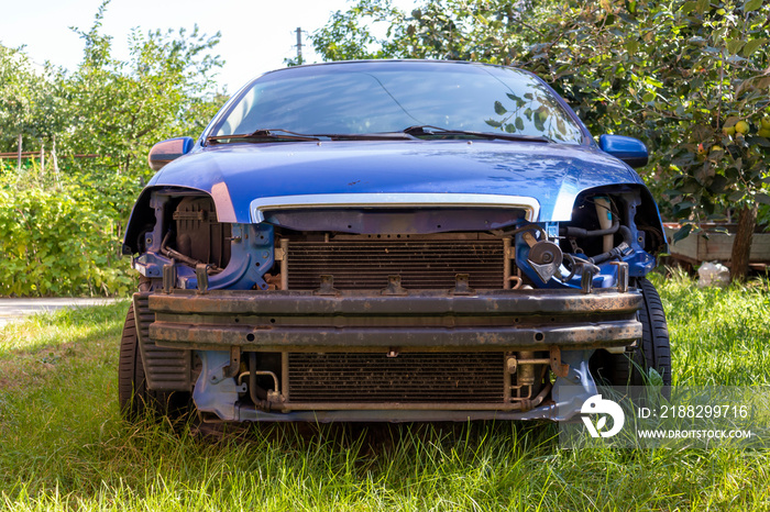 An old car is in the yard. A broken car stands on green grass.