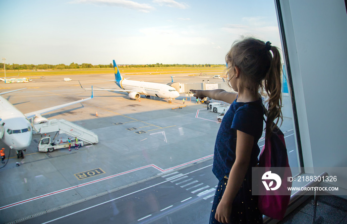 一个女孩在机场看着飞机。选择性聚焦。
