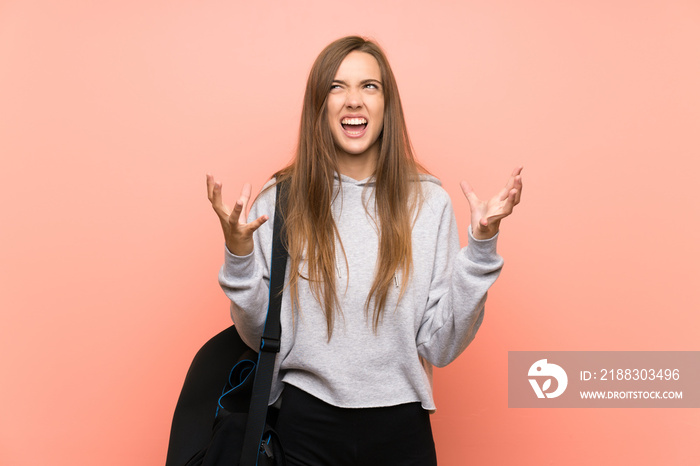 Young sport woman over isolated pink background unhappy and frustrated with something