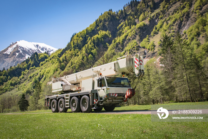 Schwerer  mobiler Ausleger - Kranwagen vor Alpenkulisse