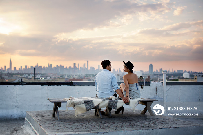 Rear view of couple sitting on roof of building