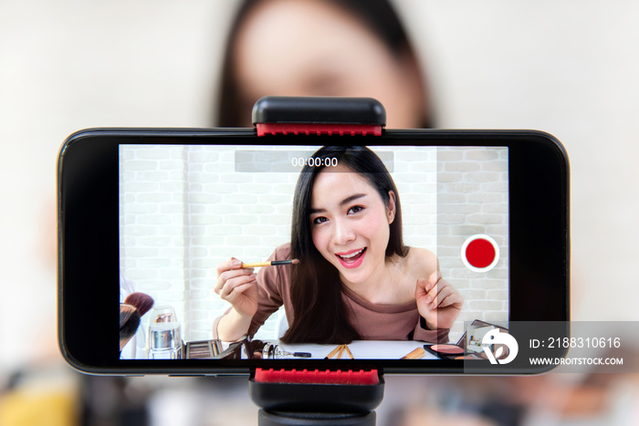 亚洲美女用智能手机录制化妆教程视频