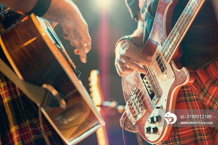 Guitarist and bassist pop musicians during a group performance.