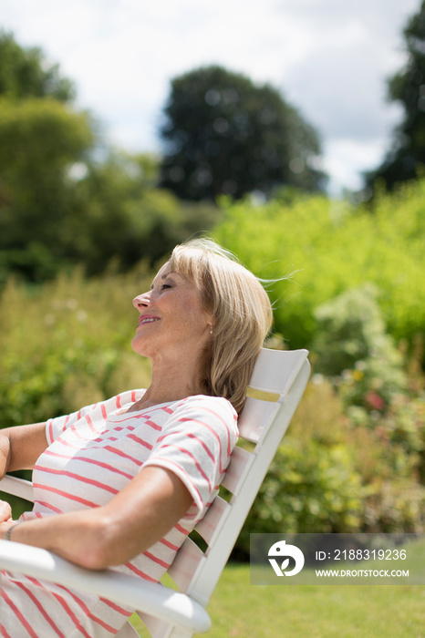 Serene senior woman relaxing in sunny garden