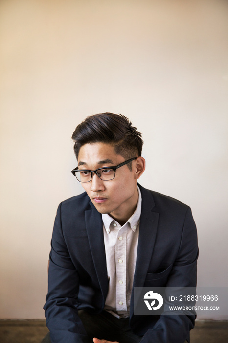 Young man wearing suit sitting indoors