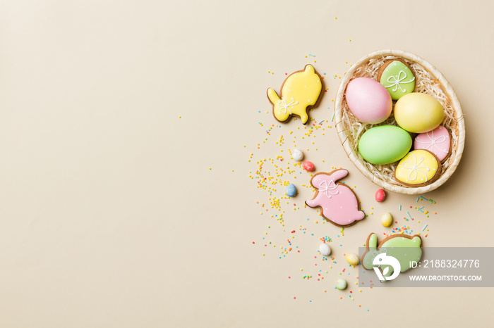 篮子里五颜六色的复活节饼干，彩色背景上有五颜六色的复活节彩蛋。Pastel颜色