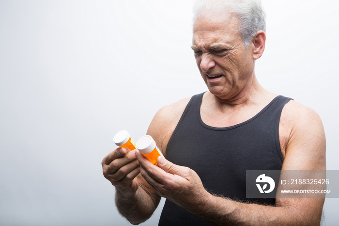 Senior man looking at pill bottles