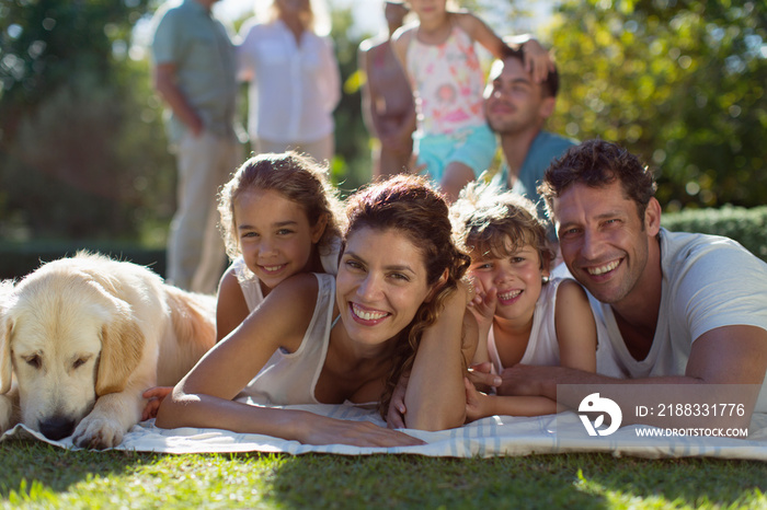 Portrait happy family with dog relaxing on blanket