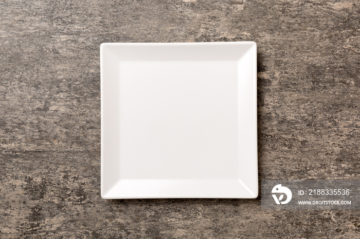 Top view of empty square plate on cement background. Empty space for your design