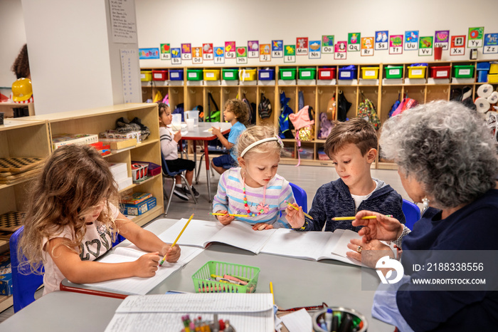 Teacher helping children with their classwork