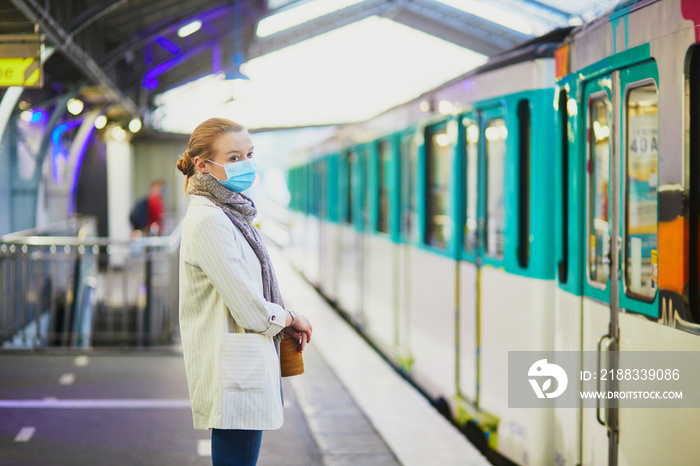 Girl travelling in a train of Parisian underground, wearing protective face mask during coronavirus 