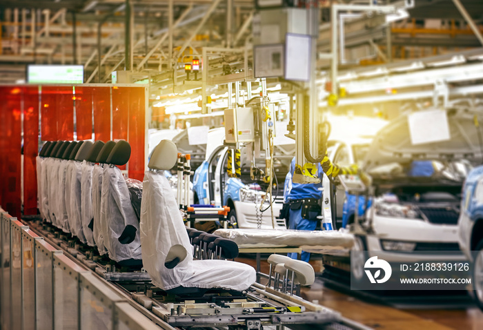 In a large factory, the car seat installation line is working.