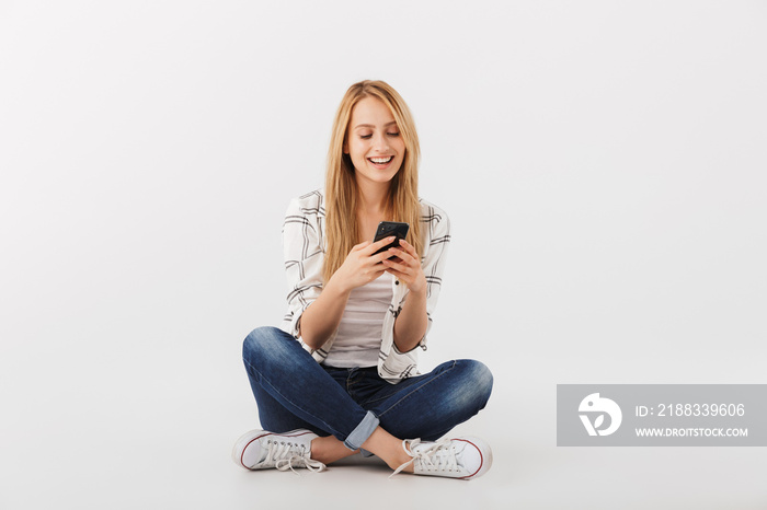 Portrait of angry young casual girl using mobile phone