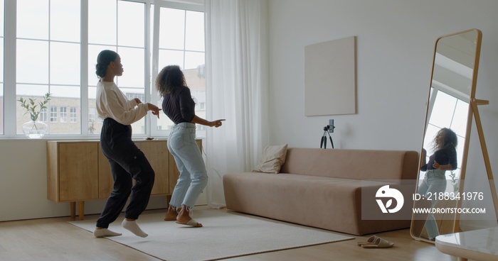 Two African-American Black girls recording trendy dance moves for social media account