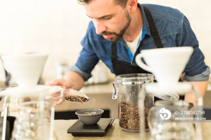 Barista carefully weighing coffee grains