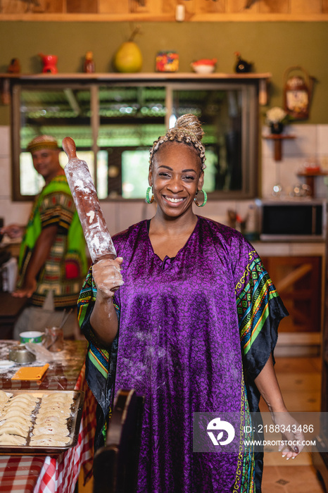 Retrato de una hermosa mujer afrocaribeña muy sonriente con un vestido caribeño de pie en el interio