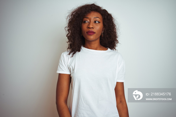 一位身穿t恤的年轻非裔美国女性站在孤立的白色背景下，面带微笑