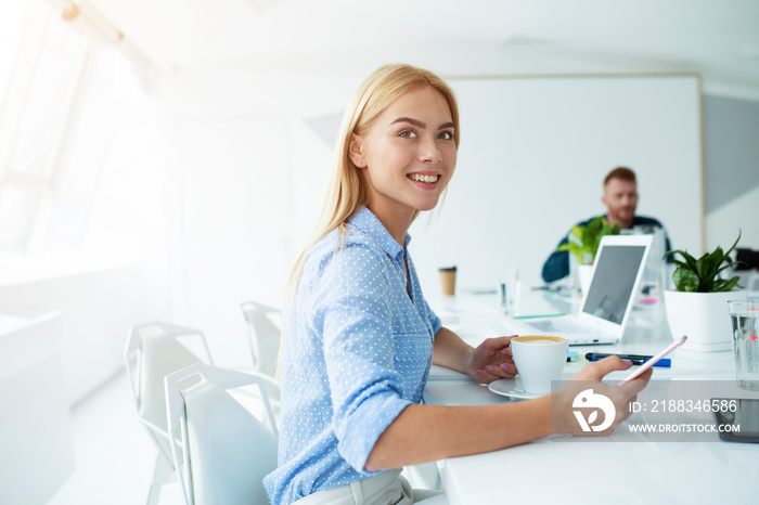 Happy woman takes a coffee break during her work