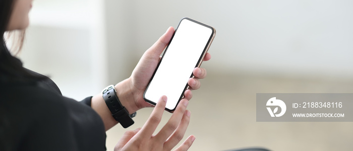 Cropped shot womans holding her smartphone with empty screen.