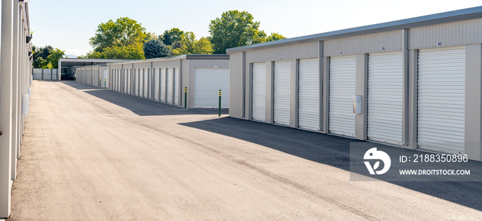 Mini garages of a storage unit facility with trees