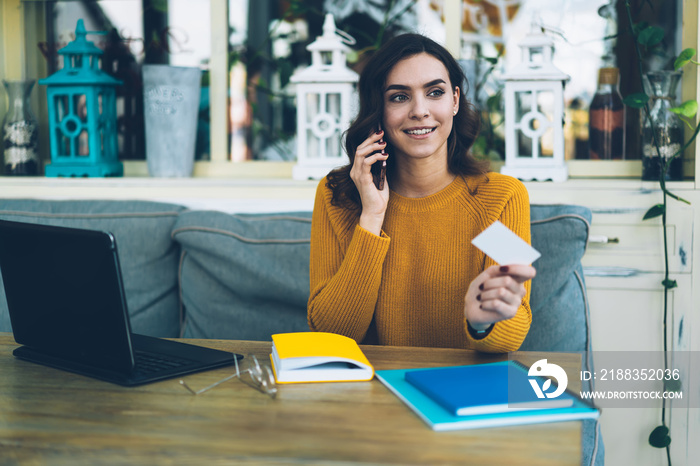 Cheerful woman freelancer calling number on business card