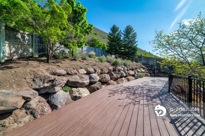 Hillside wooden deck with metal railings and a view of a slope of the mountain