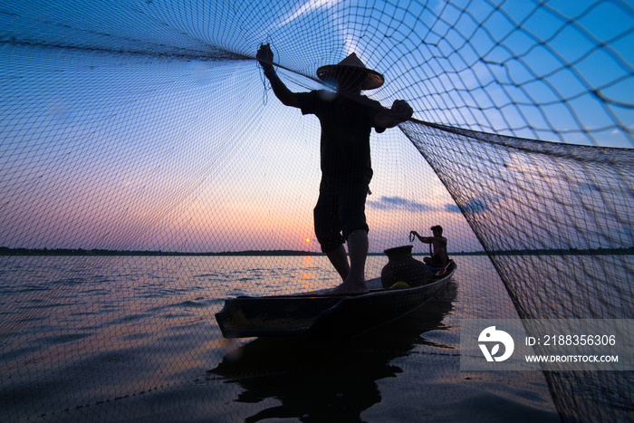 日落时渔夫撒网的剪影。