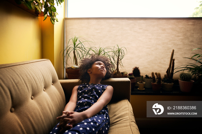 Thoughtful girl relaxing on sofa at home