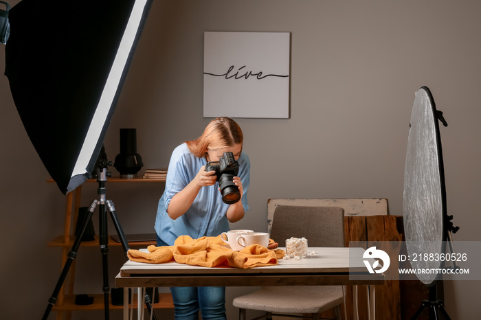 Young woman taking picture of drink with marshmallows in professional studio