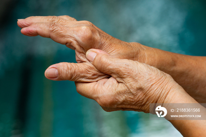 Trigger Finger, Senior womans left hand massaging her thumb finger, Suffering from pain, Close up a