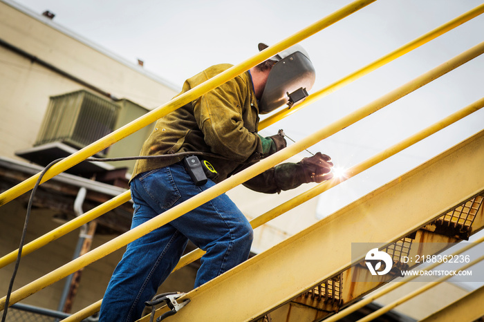 Side view of welder working on staircase