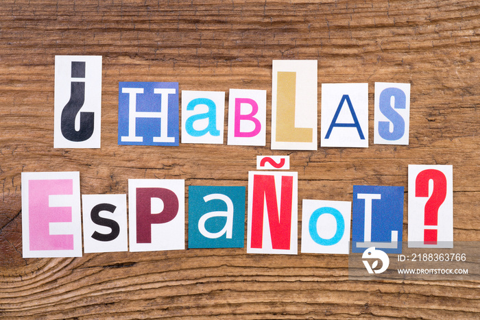 问Hablas Espanol？在木背景上的剪切杂志信件中