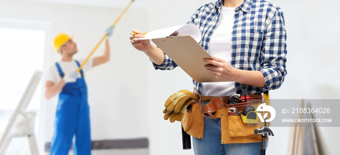 repair, construction and building concept - close up of woman or builder with clipboard, pencil and 