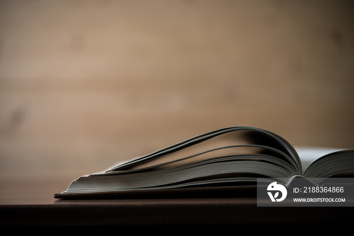 Close up of opened book on wooden table. Education concept.