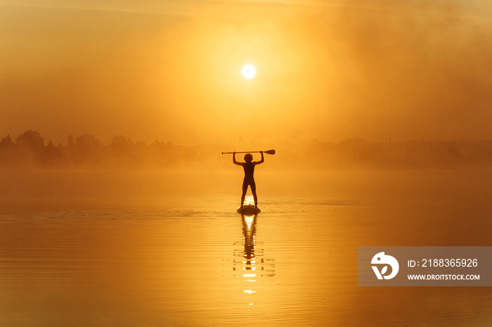 Man holding paddle above head while standing on sup board