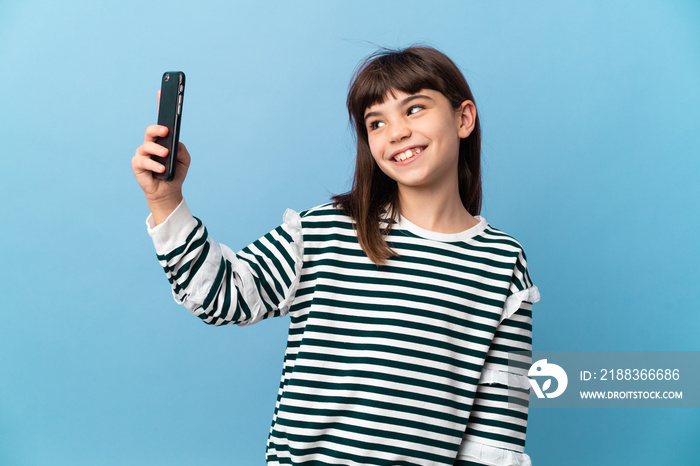 Little girl over isolated background making a selfie