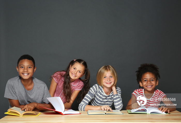 Cute kids reading books on grey background