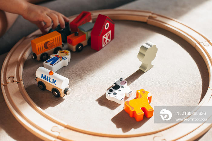 小男孩在玩木制铁路，玩具火车在铁轨上行驶。儿童教育。